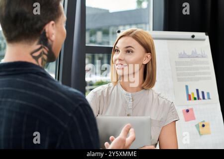 Due giovani professionisti condividono idee e collaborano in un ufficio moderno. Foto Stock