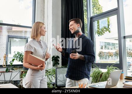 Due giovani professionisti condividono idee e collaborano in un'elegante atmosfera da ufficio. Foto Stock