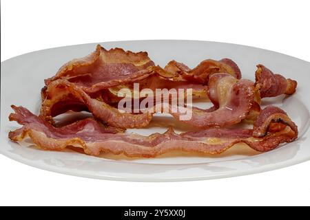 Scottature di pancetta croccante cotta a strisce su un piatto isolato su uno sfondo bianco Foto Stock