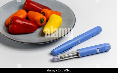 Penna per iniezione di insulina Ozempic per diabetici e perdita di peso su piatto con verdure. Foto di alta qualità Foto Stock