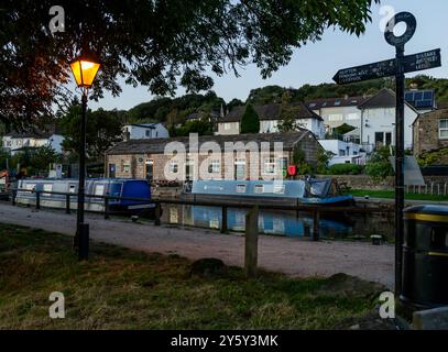 Il Leeds & Liverpool Canal in cima alle cinque chiuse a Bingley, Yorkshire, alla luce della sera. Il Five Rise Cafe e' sullo sfondo. Foto Stock