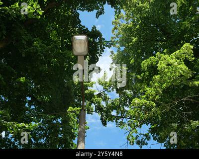 Una vecchia lampada da strada deteriorata di DDR Times. Il palo in cemento danneggiato e l'impianto di illuminazione usurato evidenziano la necessità di modernizzazione. Foto Stock