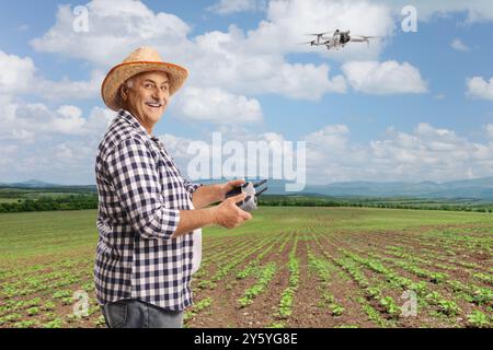 Agricoltore che vola con un drone su un campo con piante, agricoltura intelligente e tecnologia avanzata Foto Stock