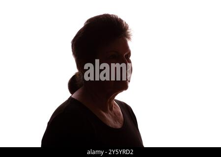 Silhouette scura di una donna anziana, una pensionessa con capelli ricci - isolata, sfondo bianco Foto Stock