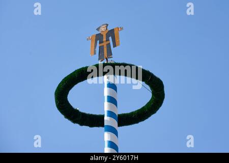 Monaco, Baviera, Germania - 23 settembre 2024: Il maypole con il Münchner Kindl, simbolo della città, si erge come simbolo della tradizione bavarese all'Oktoberfest *** Der Maibaum mit dem Münchner Kindl, dem Symbol der Stadt, steht als Wahrzeichen der bayerischen Tradition auf dem Oktoberfest Foto Stock