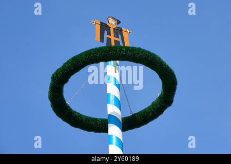 Monaco, Baviera, Germania - 23 settembre 2024: Il maypole con il Münchner Kindl, simbolo della città, si erge come simbolo della tradizione bavarese all'Oktoberfest *** Der Maibaum mit dem Münchner Kindl, dem Symbol der Stadt, steht als Wahrzeichen der bayerischen Tradition auf dem Oktoberfest Foto Stock