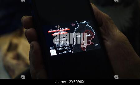 Una persona anziana possiede uno smartphone con un messaggio inviato dall'IDF ai residenti nel sud del Libano e a Beqaa, avvertendoli di stare lontano dagli edifici utilizzati da Hezbollah per immagazzinare armi, dopo che l'esercito israeliano ha promesso di effettuare attacchi più estesi e precisi contro Hezbollah il 22 settembre 2024 Foto Stock