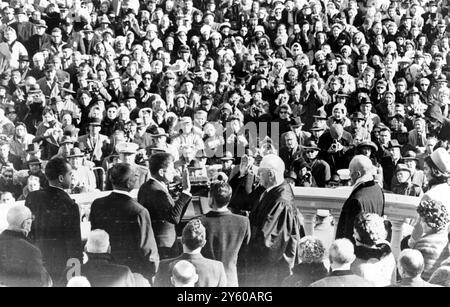 Questa vista da dietro la piattaforma ufficiale mostra gli spettatori che guardano mentre John F Kennedy giura come presidente degli Stati Uniti, il 20 gennaio 1961. LtoR sono l'ex vicepresidente Richard Nixon; il vicepresidente Lyndon Johnson; il presidente Kennedy; James R Browning, Clerk della Corte suprema degli Stati Uniti; il giudice capo Earl Warren; l'ex presidente Eisenhower e la signora Jackie Kennedy, moglie del nuovo presidente. WASHINGTON DC, USA22 GENNAIO 1961 Foto Stock