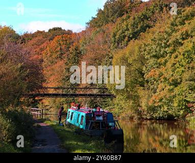 Mentre i colori autunnali cominciano a mostrare una barca stretta e blu del canale è ormeggiata sul canale di Leeds e Liverpool a Crooke, a ovest di Wigan. Foto Stock