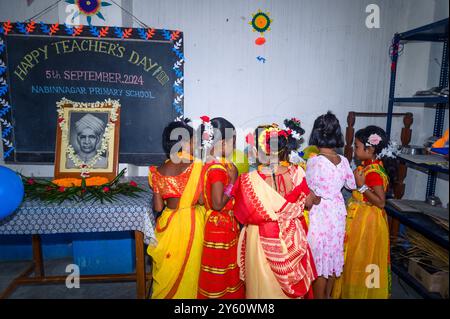 La Nabin Nagar Primary School è una remota scuola rurale situata a Nabin Nagar, lungo il confine tra India e Bangladesh. Nonostante le sfide, la scuola celebra il giorno degli insegnanti il 5 settembre, in occasione del compleanno del Dr. Sarvepalli Radhakrishnan, secondo presidente dell'India. Il preside della scuola prende l'iniziativa di organizzare la celebrazione, preparando ghirlande di fiori di calendula per le sue studentesse prima della loro esibizione di danza. Nabin Nagar, Bengala Occidentale, India. Foto Stock