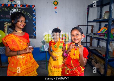 La Nabin Nagar Primary School è una remota scuola rurale situata a Nabin Nagar, lungo il confine tra India e Bangladesh. Nonostante le sfide, la scuola celebra il giorno degli insegnanti il 5 settembre, in occasione del compleanno del Dr. Sarvepalli Radhakrishnan, secondo presidente dell'India. Il preside della scuola prende l'iniziativa di organizzare la celebrazione, preparando ghirlande di fiori di calendula per le sue studentesse prima della loro esibizione di danza. Nabin Nagar, Bengala Occidentale, India. Foto Stock