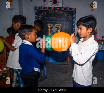 La Nabin Nagar Primary School è una remota scuola rurale situata a Nabin Nagar, lungo il confine tra India e Bangladesh. Nonostante le sfide, la scuola celebra il giorno degli insegnanti il 5 settembre, in occasione del compleanno del Dr. Sarvepalli Radhakrishnan, secondo presidente dell'India. Il preside della scuola prende l'iniziativa di organizzare la celebrazione, preparando ghirlande di fiori di calendula per le sue studentesse prima della loro esibizione di danza. Nabin Nagar, Bengala Occidentale, India. Foto Stock