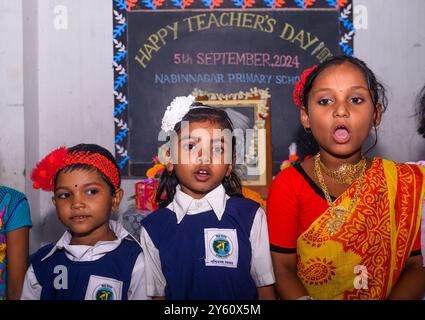 La Nabin Nagar Primary School è una remota scuola rurale situata a Nabin Nagar, lungo il confine tra India e Bangladesh. Nonostante le sfide, la scuola celebra il giorno degli insegnanti il 5 settembre, in occasione del compleanno del Dr. Sarvepalli Radhakrishnan, secondo presidente dell'India. Il preside della scuola prende l'iniziativa di organizzare la celebrazione, preparando ghirlande di fiori di calendula per le sue studentesse prima della loro esibizione di danza. Nabin Nagar, Bengala Occidentale, India. Foto Stock