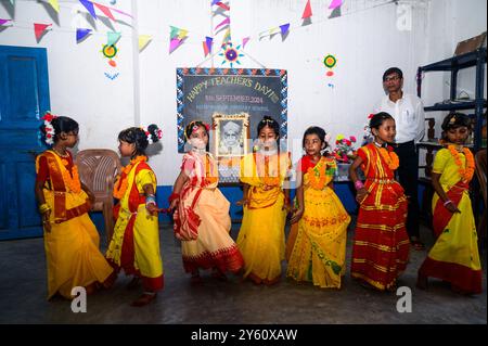 La Nabin Nagar Primary School è una remota scuola rurale situata a Nabin Nagar, lungo il confine tra India e Bangladesh. Nonostante le sfide, la scuola celebra il giorno degli insegnanti il 5 settembre, in occasione del compleanno del Dr. Sarvepalli Radhakrishnan, secondo presidente dell'India. Il preside della scuola prende l'iniziativa di organizzare la celebrazione, preparando ghirlande di fiori di calendula per le sue studentesse prima della loro esibizione di danza. Nabin Nagar, Bengala Occidentale, India. Foto Stock