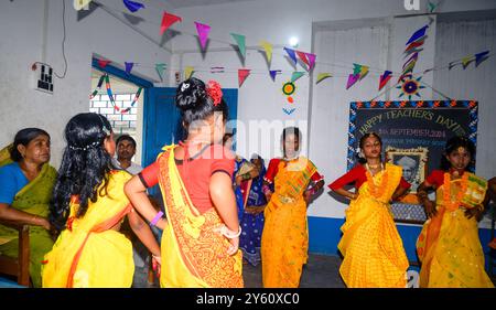 La Nabin Nagar Primary School è una remota scuola rurale situata a Nabin Nagar, lungo il confine tra India e Bangladesh. Nonostante le sfide, la scuola celebra il giorno degli insegnanti il 5 settembre, in occasione del compleanno del Dr. Sarvepalli Radhakrishnan, secondo presidente dell'India. Il preside della scuola prende l'iniziativa di organizzare la celebrazione, preparando ghirlande di fiori di calendula per le sue studentesse prima della loro esibizione di danza. Nabin Nagar, Bengala Occidentale, India. Foto Stock