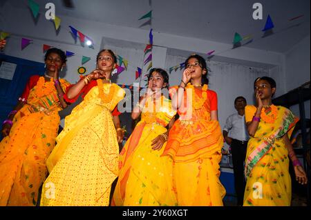 La Nabin Nagar Primary School è una remota scuola rurale situata a Nabin Nagar, lungo il confine tra India e Bangladesh. Nonostante le sfide, la scuola celebra il giorno degli insegnanti il 5 settembre, in occasione del compleanno del Dr. Sarvepalli Radhakrishnan, secondo presidente dell'India. Il preside della scuola prende l'iniziativa di organizzare la celebrazione, preparando ghirlande di fiori di calendula per le sue studentesse prima della loro esibizione di danza. Nabin Nagar, Bengala Occidentale, India. Foto Stock