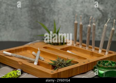 Scatola in legno di colore chiaro con articolazioni e marijuana fresca e vecchie pareti in pietra Foto Stock