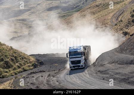 Provincia di Bitlis, Turchia, 6 luglio 2024; Mercedes Truck Driving on a Rural Road. Mercedes Truck che guida su una strada rurale polverosa a Bitlis in Turchia. Foto Stock