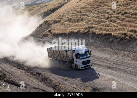 Provincia di Bitlis, Turchia, 6 luglio 2024; Mercedes Truck Driving on a Rural Road. Mercedes Truck che guida su una strada rurale polverosa a Bitlis in Turchia. Foto Stock