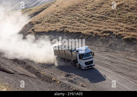 Provincia di Bitlis, Turchia, 6 luglio 2024; Mercedes Truck Driving on a Rural Road. Mercedes Truck che guida su una strada rurale polverosa a Bitlis in Turchia. Foto Stock