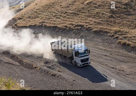 Provincia di Bitlis, Turchia, 6 luglio 2024; Mercedes Truck Driving on a Rural Road. Mercedes Truck che guida su una strada rurale polverosa a Bitlis in Turchia. Foto Stock