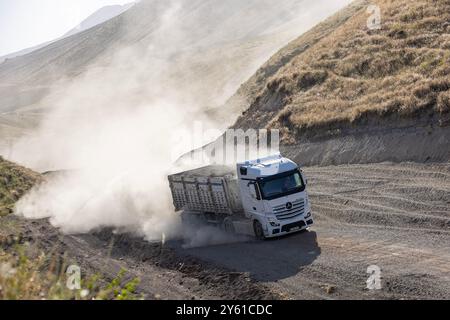 Provincia di Bitlis, Turchia, 6 luglio 2024; Mercedes Truck Driving on a Rural Road. Mercedes Truck che guida su una strada rurale polverosa a Bitlis in Turchia. Foto Stock