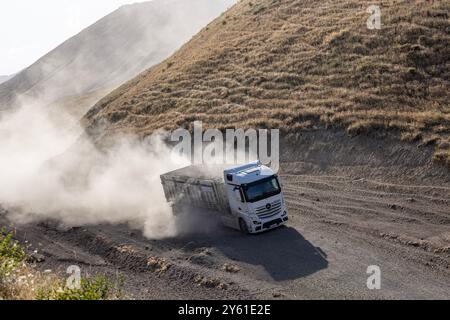 Provincia di Bitlis, Turchia, 6 luglio 2024; Mercedes Truck Driving on a Rural Road. Mercedes Truck che guida su una strada rurale polverosa a Bitlis in Turchia. Foto Stock