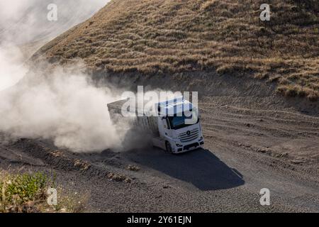 Provincia di Bitlis, Turchia, 6 luglio 2024; Mercedes Truck Driving on a Rural Road. Mercedes Truck che guida su una strada rurale polverosa a Bitlis in Turchia. Foto Stock