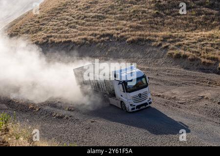 Provincia di Bitlis, Turchia, 6 luglio 2024; Mercedes Truck Driving on a Rural Road. Mercedes Truck che guida su una strada rurale polverosa a Bitlis in Turchia. Foto Stock