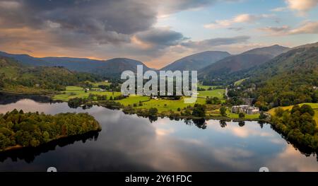 Paesaggio panoramico aereo del villaggio e del lago di Grasmere nel Parco Nazionale del Lake District con una splendida alba e acque calme Foto Stock