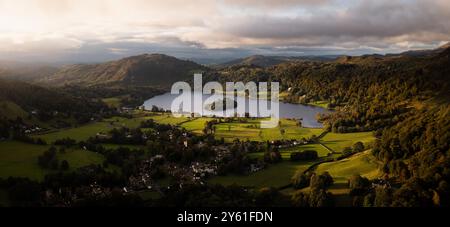 Paesaggio panoramico aereo del villaggio e del lago di Grasmere nel Parco Nazionale del Lake District con una splendida alba e acque calme Foto Stock