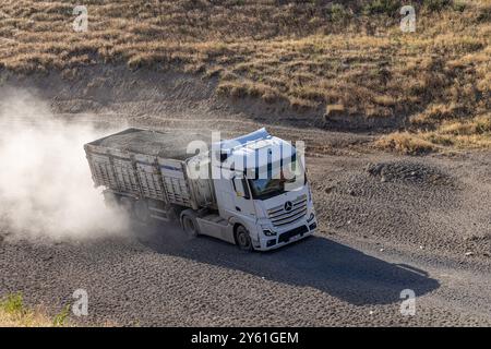 Provincia di Bitlis, Turchia, 6 luglio 2024; Mercedes Truck Driving on a Rural Road. Mercedes Truck che guida su una strada rurale polverosa a Bitlis in Turchia. Foto Stock