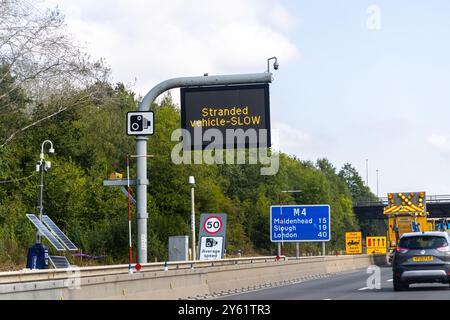 Londra, Regno Unito - 19 settembre 2024: Segnale stradale avvisa di veicolo in panne e traffico lento sulla M4. Foto Stock