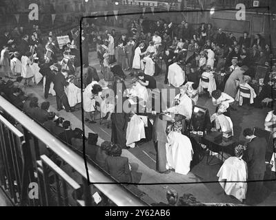 I parrucchieri britannici hanno avuto un'intensa domenica libera oggi, quando si sono riuniti alla Seymour Hall e Marylebone per competere per il Silver Rose Bowl Contest, organizzato dalla Fellowship of Hair Artists of Great Britain. In un concorso aperto solo ai partecipanti britannici, è stato utilizzato uno stile set - la moda Fellowship Winter per il 1948. Immagini: Una visione generale della scena mentre i concorrenti preparano i loro modelli per i giudici della Seymour Hall. 7 dicembre 1947 Foto Stock