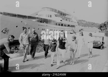 Jacqueline Kennnedy cammina a piedi nudi con i suoi due figli John Kennedy Junior (a sinistra) e Caroline (a destra) lungo la banchina sull'isola di Skorpios , accanto alla Christina , lo yacht del futuro marito Aristotele Onassis . 19 ottobre 1968 Foto Stock