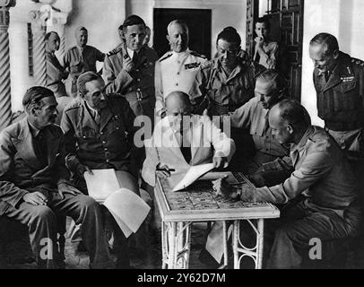 Il primo ministro, seduto in un quartier generale di forze leggere ad Algeri strategia ai capi dei servizi raggruppati su di lui, (da sinistra a destra) Mr. Anthony Eden, Sir Allan Brooke , Air Chief-Marshal Tedder, Admiral Sir Andrew Cunningham , General Sir H.. Alexander , General Marshall (U.S.A.), General Eisenhower e General Montgomery . 12 giugno 1943 Foto Stock