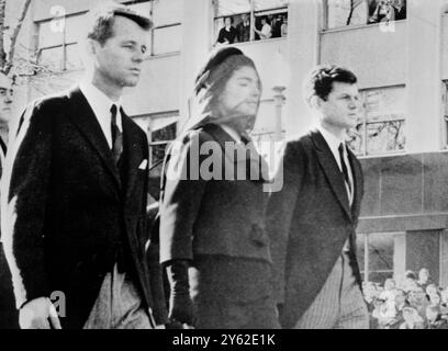 Washington , D . C . La signora Jacqueline Kennedy , affiancata da Bother in Law , il procuratore generale Robert Kennedy ( a sinistra ) , e il senatore Edward Kennedy ( a destra ) , segue la bara del defunto marito mentre la processione funebre del 35° presidente assassinato degli Stati Uniti ha lasciato la Casa Bianca il 25 novembre dopo una cerimonia nella Cattedrale di St Matthews , il defunto presidente è stato sepolto nel cimitero nazionale di Arlington . 27 novembre 1963 Foto Stock