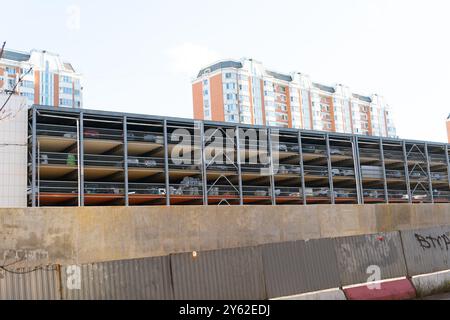 parco sullo sfondo, parcheggio bianco, garage, architettura postmoderna, parcheggio multiplo moderno, rampa a pagamento Foto Stock