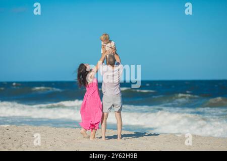 Vista ad angolo basso dei genitori che sollevano il doppio contro il cielo Foto Stock