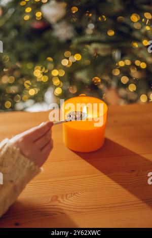 Fortuna con la fusione dello stagno. Statuetta di trifoglio di stagno nel cucchiaio sopra la fiamma della candela. Set per versare il piombo per raccontare la fortuna di Natale. Festa di Capodanno. Foto Stock