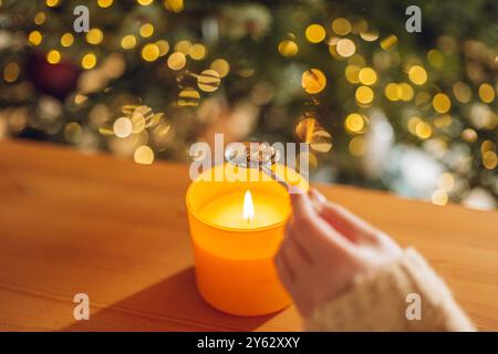 Set di spilli di piombo per raccontare la fortuna di Natale. Fortuna con la fusione dello stagno. stagnare la statuetta del trifoglio nel cucchiaio sopra la fiamma di candela in una mano sul natale Foto Stock