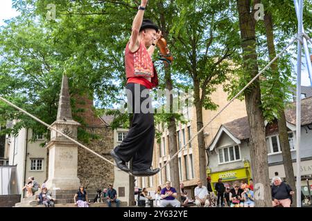 Oxford Regno Unito - luglio 25 2024; Street entertainer in equilibrio su Slack-line mentre suona il violino. Foto Stock