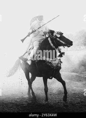 Catturando l'intensità di una tradizionale Tbourida marocchina, nota anche come Fantasia, dove abili cavalieri galoppo in formazione e fucili da fuoco. Foto Stock