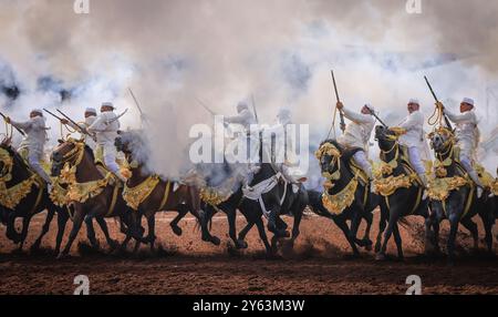 Catturando l'intensità di una tradizionale Tbourida marocchina, nota anche come Fantasia, dove abili cavalieri galoppo in formazione e fucili da fuoco. Foto Stock