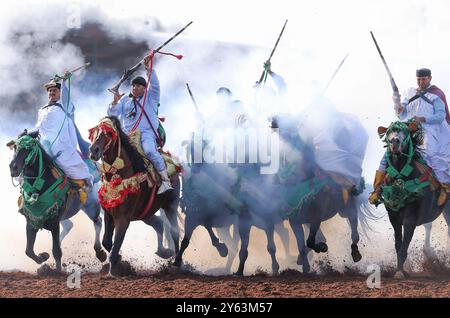 Catturando l'intensità di una tradizionale Tbourida marocchina, nota anche come Fantasia, dove abili cavalieri galoppo in formazione e fucili da fuoco. Foto Stock