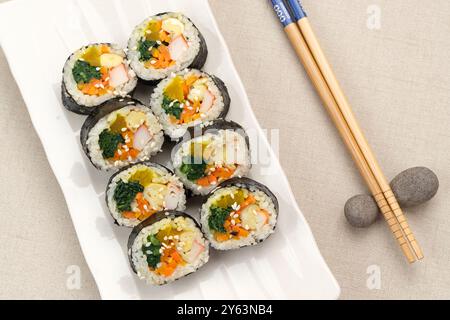 Gimbap laminato coreano, a base di riso, cetriolo, tonno, carote, salsiccia, bastoncino di granchio e avvolto con lavatrice di alghe. Foto Stock