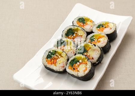 Gimbap laminato coreano, a base di riso, cetriolo, tonno, carote, salsiccia, bastoncino di granchio e avvolto con lavatrice di alghe. Foto Stock