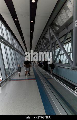 Londra Regno Unito - 14 agosto 2024: Viaggiatori in lungo cammino fino al cancello per la partenza del viaggio Foto Stock