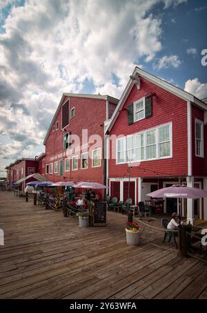 Il Museo della pesca dell'Atlantico, Center, e la Shipwright Brewing Company, Lunenburg nuova Scozia, Canada. La Shipwright Brewing Company al primo piano, in primo piano, e il museo a tre piani in uno storico edificio del 1876, rosso brillante, sul lungomare di Lunenburg. Foto Stock