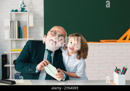 Vecchio insegnante e giovane scolaro. I bambini imparano la scienza. Giornata degli insegnanti. Foto Stock